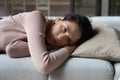 Unhappy young woman feeling bored, lying alone on sofa.