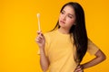 Unhappy young woman look at toothbrush, get unsatisfied it Attractive beautiful girl canÃ¢â¬â¢t choose good quality of toothbrush