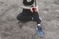 Unhappy young woman sitting in the garden, grabbing an ankle, un Royalty Free Stock Photo