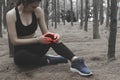 Unhappy young woman sitting in the garden, grabbing an ankle, un Royalty Free Stock Photo