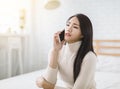 Unhappy young woman talking on mobile phone at home Royalty Free Stock Photo