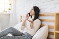 Unhappy young woman talking on mobile phone at home Royalty Free Stock Photo