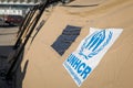 UNHCR, the UN Refugee Agency logo on a tent in a refugee camp
