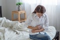 Unhealthy asian woman hands touching her belly, Looking like stomach pain on bed Royalty Free Stock Photo