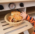 Unhealthy baby food. Baby reaching for sausage bread roll in toy Royalty Free Stock Photo