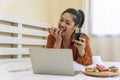 Unhealthy eating and obesity concept. Overweight fat woman holding glass sparkling water with plate doughnut while lying on the Royalty Free Stock Photo