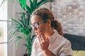 Unhealthy girl sit on couch at home touch cheek suffering from painful toothache, unhappy unwell millennial woman feel bad having Royalty Free Stock Photo