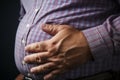 Unhealthy grip a mans hand clutches excessive belly fat