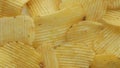 Unhealthy Harmful food, yellow delicious Potato ribbed crispy chips randomly lying on a white table background, close-up footage m