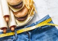 Unhealthy junk fast food and too small clothes with centimeter abstract life style concept Royalty Free Stock Photo