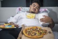 Asian obese man sleeping with junk foods Royalty Free Stock Photo