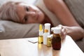 Unhealthy mature woman lying in bed, taking pills close up Royalty Free Stock Photo