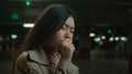 Unhealthy sick Asian woman coughing flu symptom allergy chinese japanese girl female stand in cold dark parking Royalty Free Stock Photo