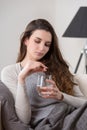 Unhealthy sick woman takes pill with glass of water