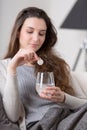 Unhealthy sick woman takes pill with glass of water