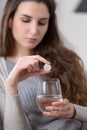 Unhealthy sick woman takes pill with glass of water