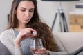 Unhealthy sick woman takes pill with glass of water