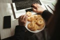 Unhealthy snack at work time, woman overeating