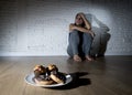 Unhealthy sugar donuts and muffins and tempted young woman or teenager girl sitting on ground