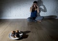 Unhealthy sugar donuts and muffins and tempted young woman or teenager girl sitting on ground