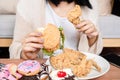 woman over eating fast food burgers, fired chicken, donuts, and desserts, Binge Eating Disorder BED concept