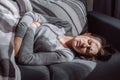 Unhealthy woman struggle with painful ache lying on couch at home. Sad unhappy young female suffering from menstrual pain, feeling Royalty Free Stock Photo