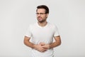 Unhealthy young man feeling pain in stomach, studio portrait. Royalty Free Stock Photo