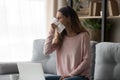 Unhealthy young woman using paper tissue, wiping runny nose.