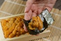 Uni Japanese sea urchin with rice and seaweed in hand