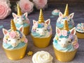 Unicorn cupcakes with buttercream icing on wooden background. generated ai