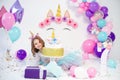 Unicorn Girl posing near happy birthday cake. Idea for decorating unicorn style birthday party. Unicorn decoration for