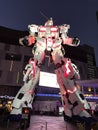 Unicorn Gundam standing in front of the Diver City Tokyo Plaza at night