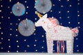 Unicorn party pinata on blue bokeh background