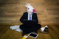 Unicorn in a suit and tie enthusiastically works at home office with a pencil in the teeth