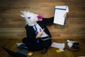 Unicorn in a suit and tie smiles and shows a white empty sheet with copy space