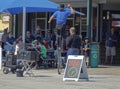 A Unicyclist performer in a black Stetson Cowboy hat entertaining a small crowd of People.