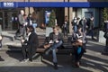 Unidentifed men reads a book on a bench with tourists in background. More than 15 million people visit London each year.