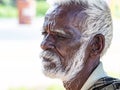 An unidentifed old senior indian poor man portrait with a dark brown wrinkled face and white hair and a white beard, looks serious Royalty Free Stock Photo