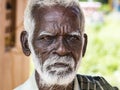 An unidentifed old senior indian poor man portrait with a dark brown wrinkled face and white hair and a white beard, looks serious Royalty Free Stock Photo