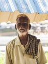 An unidentifed old senior indian poor man portrait with a dark brown wrinkled face and white hair and a white beard, looks serious Royalty Free Stock Photo