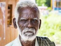 An unidentifed old senior indian poor man portrait with a dark brown wrinkled face and white hair and a white beard, looks serious Royalty Free Stock Photo