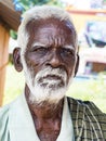 An unidentifed old senior indian poor man portrait with a dark brown wrinkled face and white hair and a white beard, looks serious Royalty Free Stock Photo