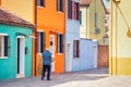 Unidentifiable rear view of a local man on the narrow colorful alleys of Burano, Venice