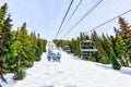 Skiers on Chairlift Up a Ski Slope in the Canadian Rockies Royalty Free Stock Photo