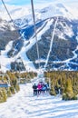 Skiers on Chairlift Up a Ski Slope in the Canadian Rockies Royalty Free Stock Photo