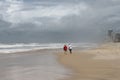 Unidentifiable tourists looking out across stormy ocean on beach at the Gold Coast - Surfers Paradise in Queensland Australia