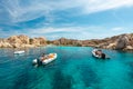 Tourists on small boats in an emerald water gulf - La Maddalena National Park - Parco Nazionale Arcipelago di La