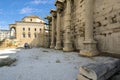 An unidentifiable young couple visit the ancient ruins of Hadrian`s Library Wall in the Plaka district of the Roman Agora of Athen