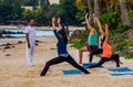 Unidentified adults participating in yoga on the beach