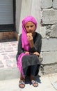 Unidentified Afghan Girl sitting and eating a cookie